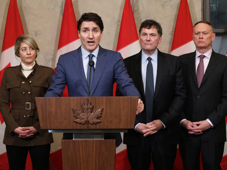 Kanadas Premierminister Justin Trudeau spricht über die US-Zölle gegen Kanada am 4. März 2025 in Ottawa, während Außenministerin Melanie Joly, der Minister für Finanzen Dominic Leblanc und der Minister für öffentliche Sicherheit David McGuinty zusehen.