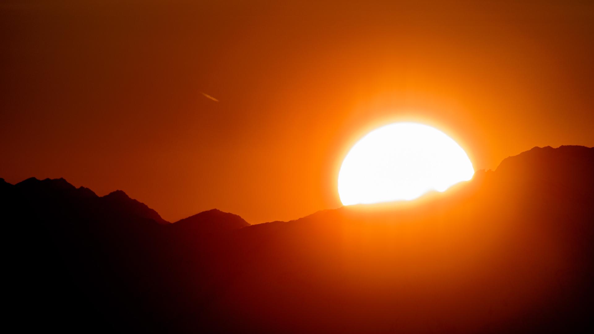 Sonne wenige Sekunden vor ihrem Untergehen hinter Gipfeln der Hohen Tauern