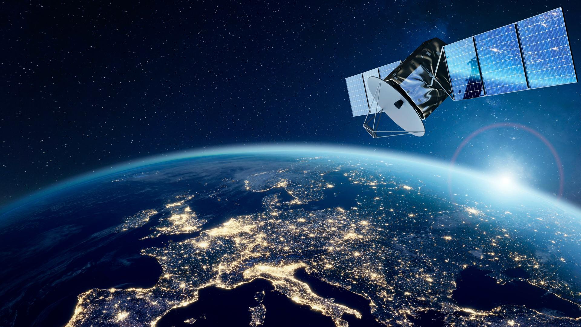 Ein Satellit schwebt über der nördlichen Erdhalbkugel, auf der nächtlichen Silhouette Europas, Nordafrikas und Vorderasiens sind künstliche Lichter zu sehen. (Illustration)