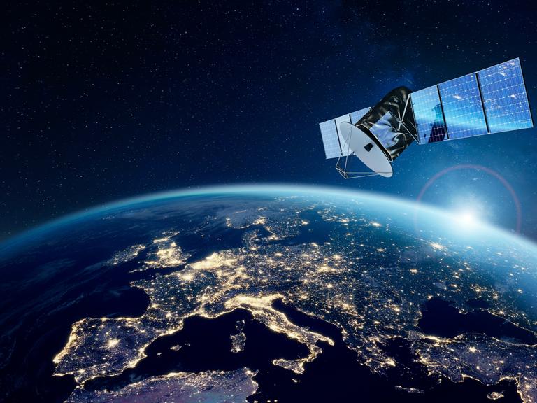 Ein Satellit schwebt über der nördlichen Erdhalbkugel, auf der nächtlichen Silhouette Europas, Nordafrikas und Vorderasiens sind künstliche Lichter zu sehen. (Illustration)