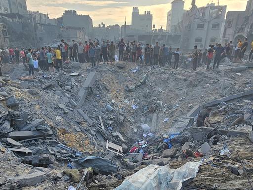 Menschen vor zerstörten Gebäuden im Flüchtlingslager Dschabalia im Gazastreifen