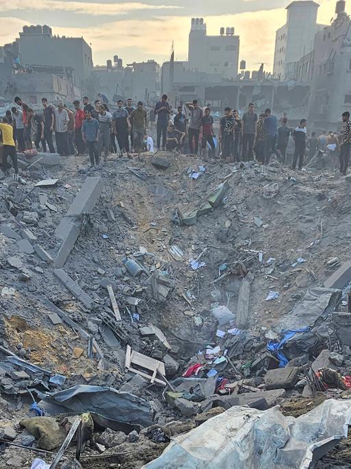 Menschen vor zerstörten Gebäuden im Flüchtlingslager Dschabalia im Gazastreifen