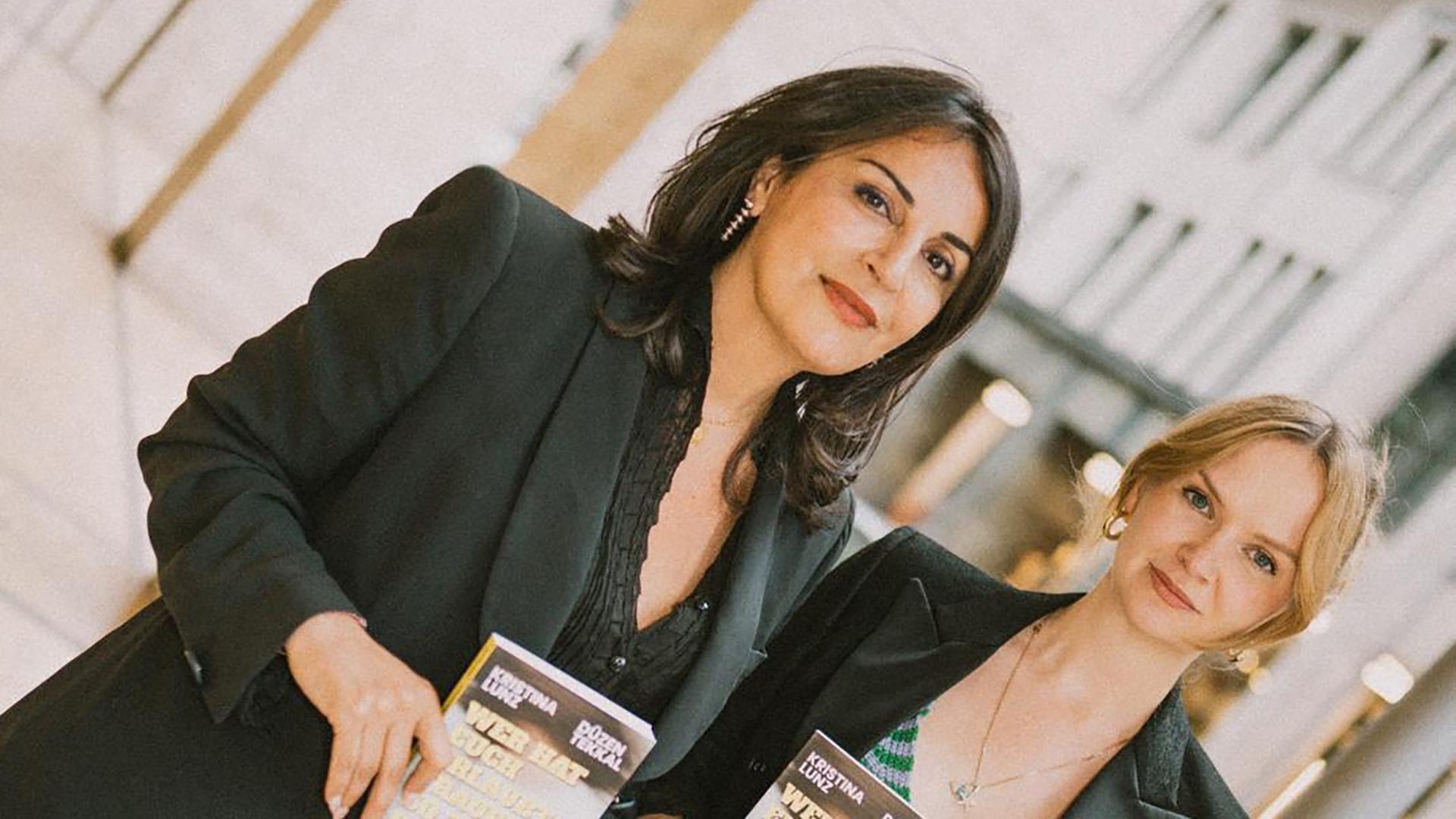 Düzen Tekkal und Kristina Lunz halten beide das Buch "Wer hat euch erlaubt, Frauen zu hassen" vor ihrem Körper Richtung Kamera.