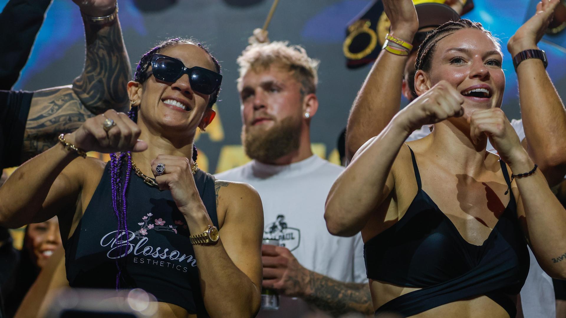 Die beiden Boxerinnen beim Wiegen vor dem Kampf: Amanda Serrano trägt eine Sonnenbrille. Sie und Nina Meinke haben die Fäuste geballt und zeigen Box-Gesten. Die beiden Boxerinnen beim Wiegen vor dem Kampf: Amanda Serrano trägt eine Sonnenbrille. Sie und Nina Meinke haben die Fäuste geballt und zeigen Box-Gesten.