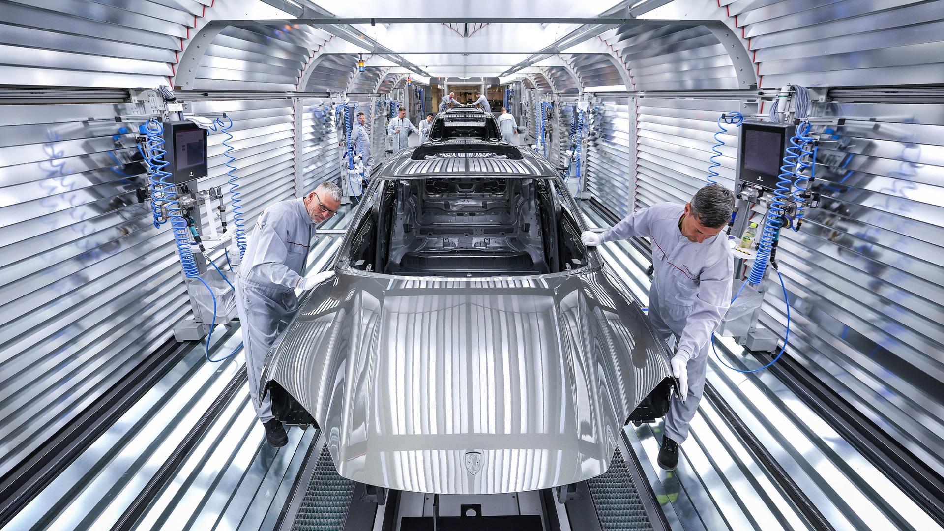 Arbeiter montieren Teile eines Porsche Macan in der Fabrik in Leipzig. Arbeiter montieren Teile eines Porsche Macan in der Fabrik in Leipzig.