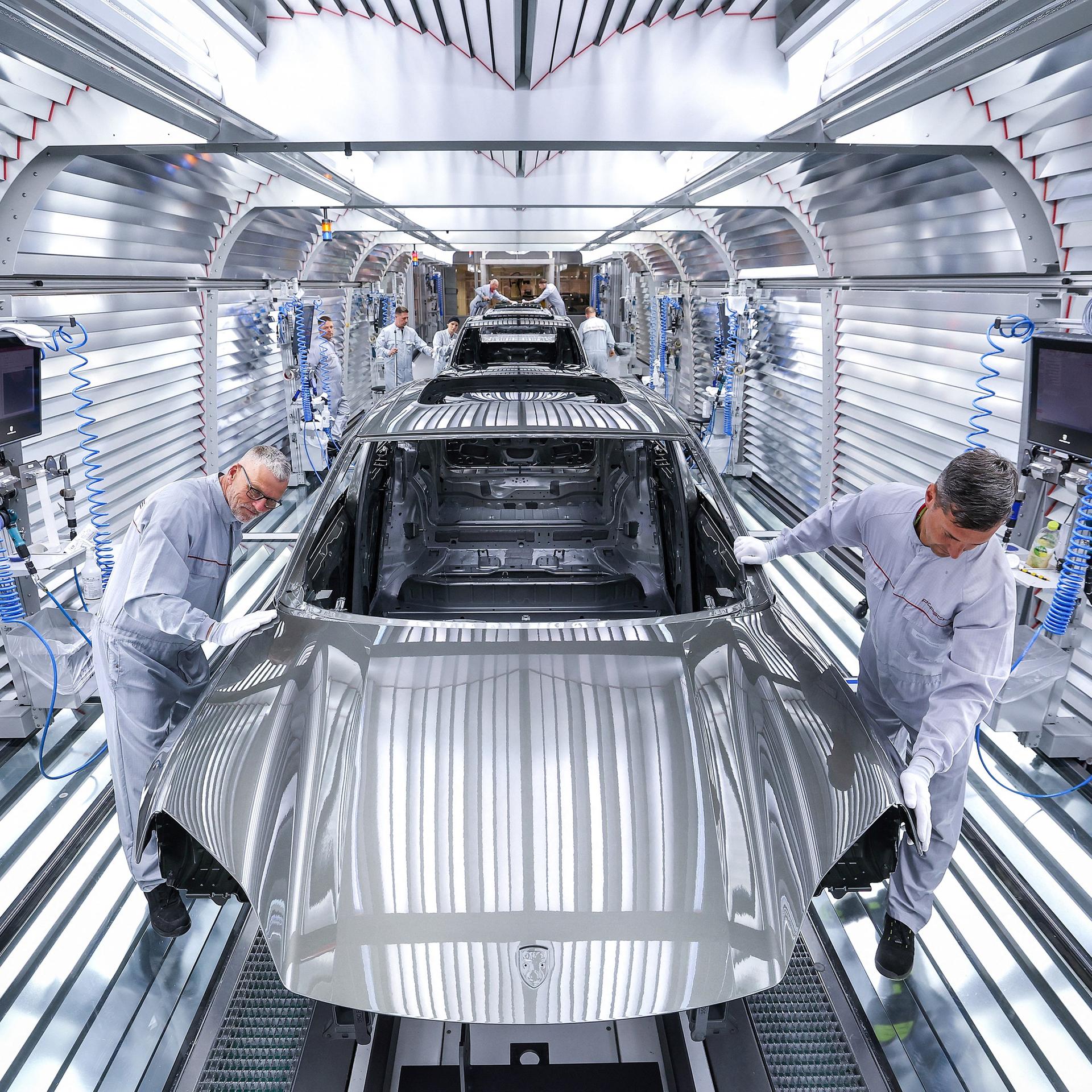 Arbeiter montieren Teile eines Porsche Macan in der Fabrik in Leipzig.