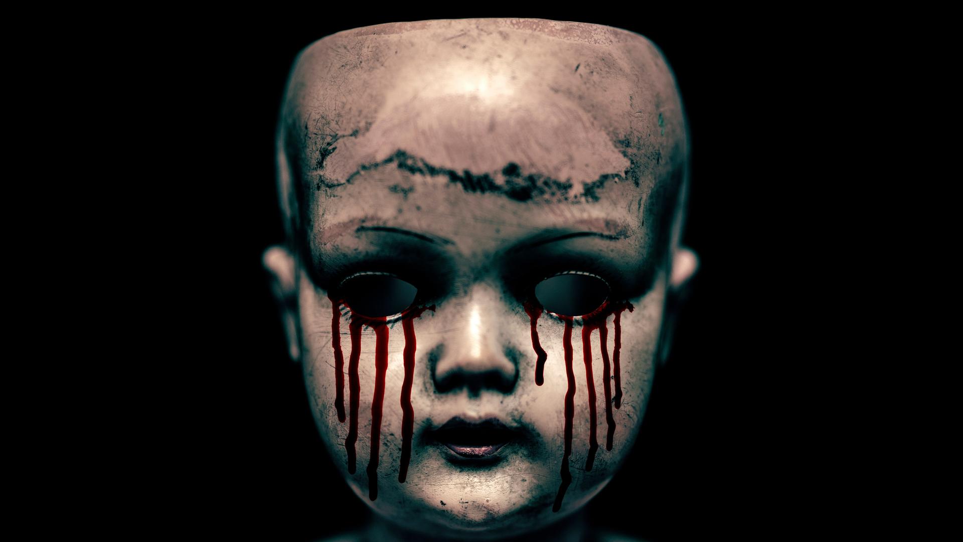 Ein gruseliger Puppenkopf mit blutenden Augen vor schwarzem Hintergrund