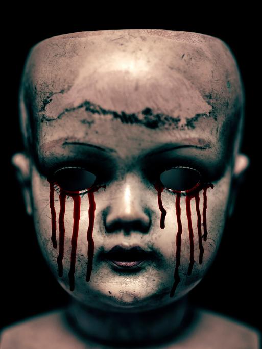 Ein gruseliger Puppenkopf mit blutenden Augen vor schwarzem Hintergrund