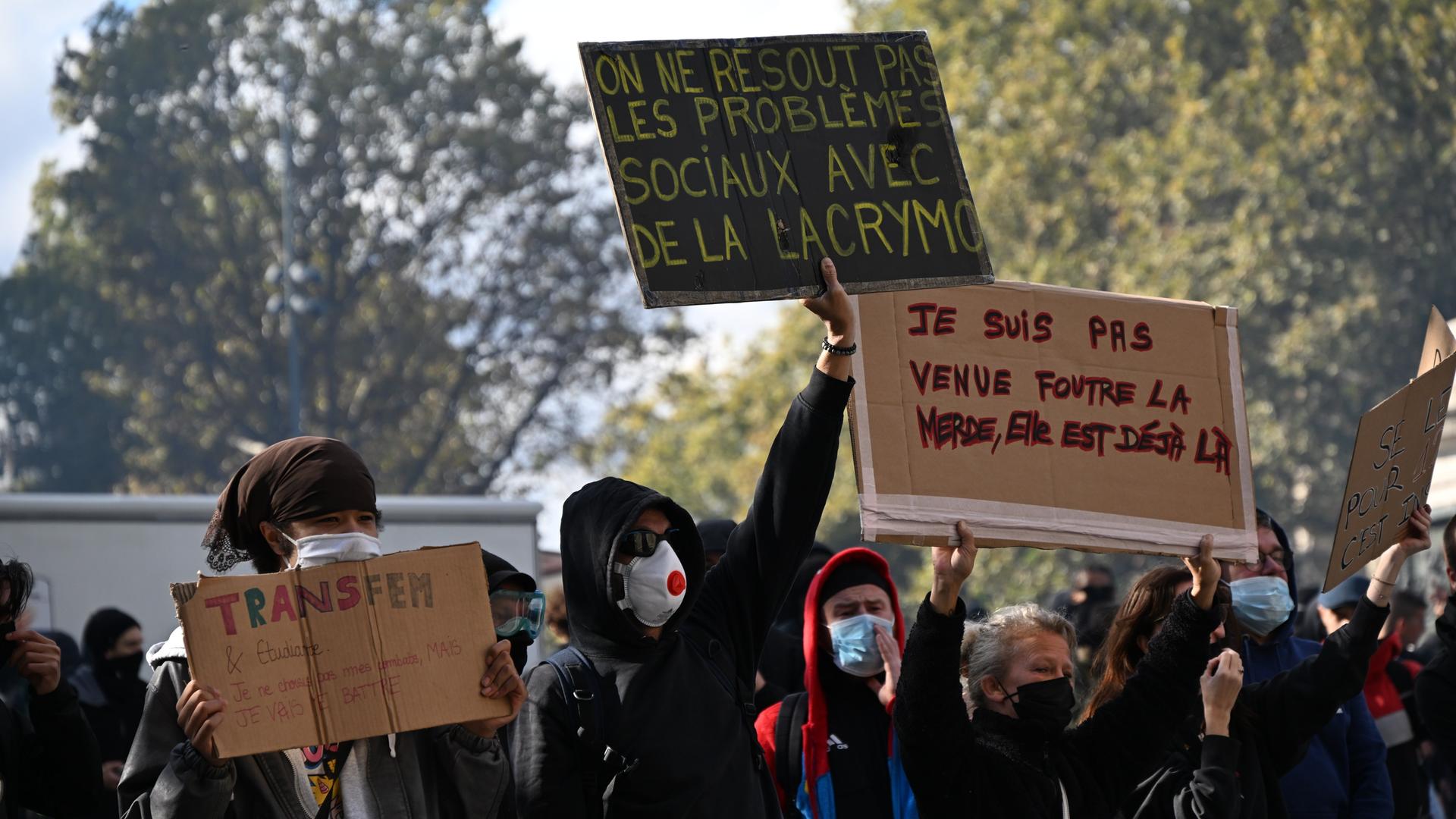 Demonstration in Frankreich: Ein Demonstrant hält ein Plakat mit der Aufschrift "Soziale Probleme löst man nicht mit Tränengas" hoch. 