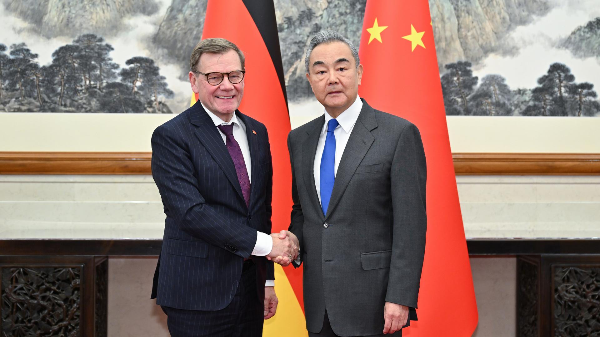 Bundesaußenminister Wadephul und sein chinesischer Amtskollege Wang stehen vor den Nationalflaggen beider Länder und geben sich die Hand.