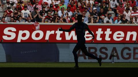 Die Aufschrift "Sportwetten" steht auf einer Werbebande bei einem Fußballspiel.