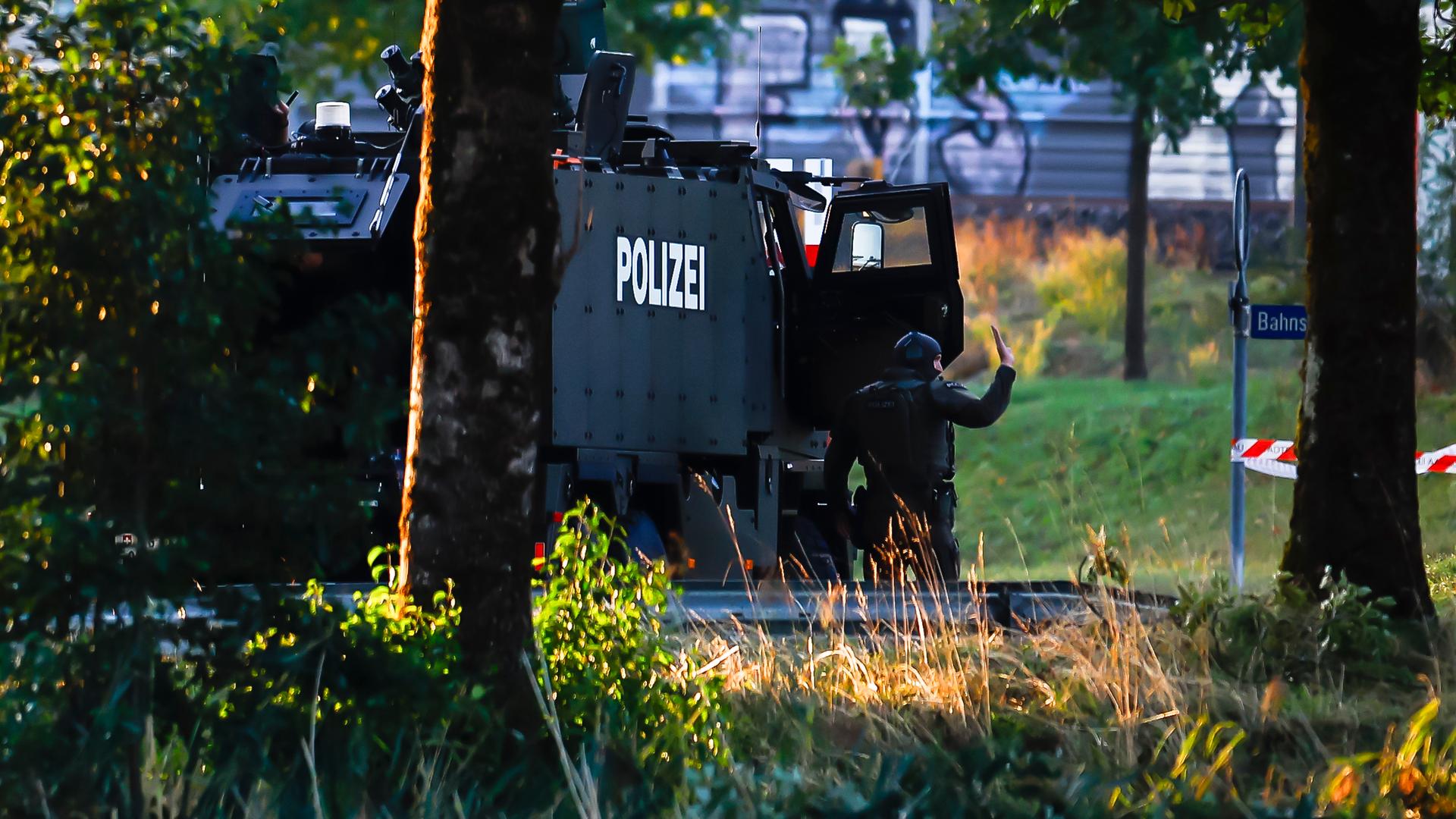 Bewaffnete Polizeibeamte mit einem gepanzerten Einsatzfahrzeug sperren eine Straße in der Nähe der Pferderennbahn in Aarau in der Schweiz ab. Bewaffnete Polizeibeamte mit einem gepanzerten Einsatzfahrzeug sperren eine Straße in der Nähe der Pferderennbahn in Aarau in der Schweiz ab.