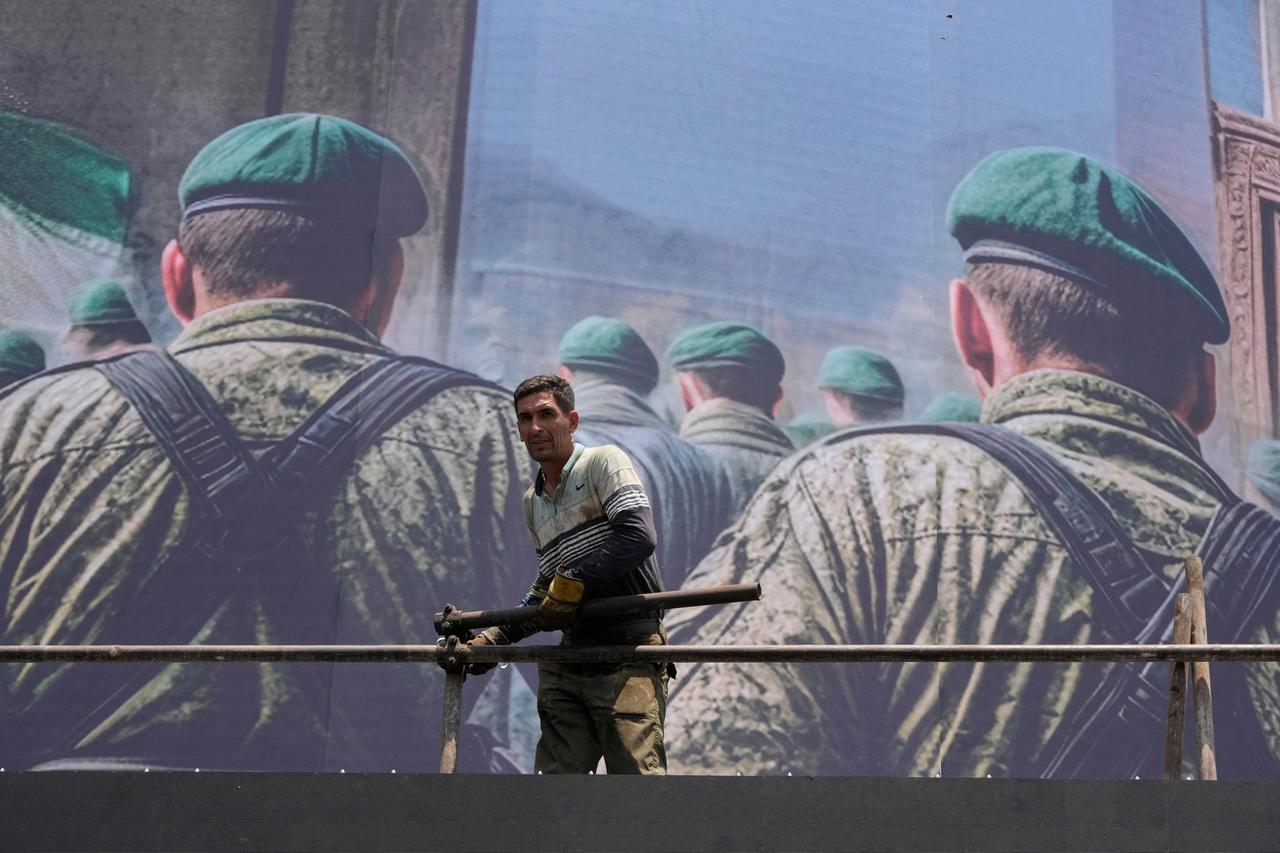 Ein Arbeiter steht auf dem Platz der Islamischen Revolution in Teheran, Iran, vor einem anti-israelischen Banner, das iranische Soldaten zeigt, die angeblich auf dem Weg sind, israelisches Gebiet anzugreifen. Ein Arbeiter steht auf dem Platz der Islamischen Revolution in Teheran, Iran, vor einem anti-israelischen Banner, das iranische Soldaten zeigt, die angeblich auf dem Weg sind, israelisches Gebiet anzugreifen.