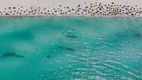 Ein Strandabschnitt mit Menschen und das Meer im türkischen Izmir sind aus der Drohnenperspektive zu sehen