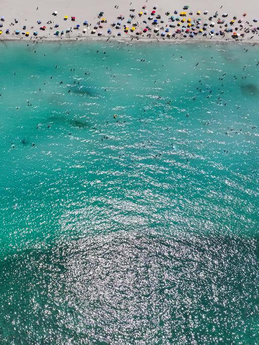 Ein Strandabschnitt mit Menschen und das Meer im türkischen Izmir sind aus der Drohnenperspektive zu sehen