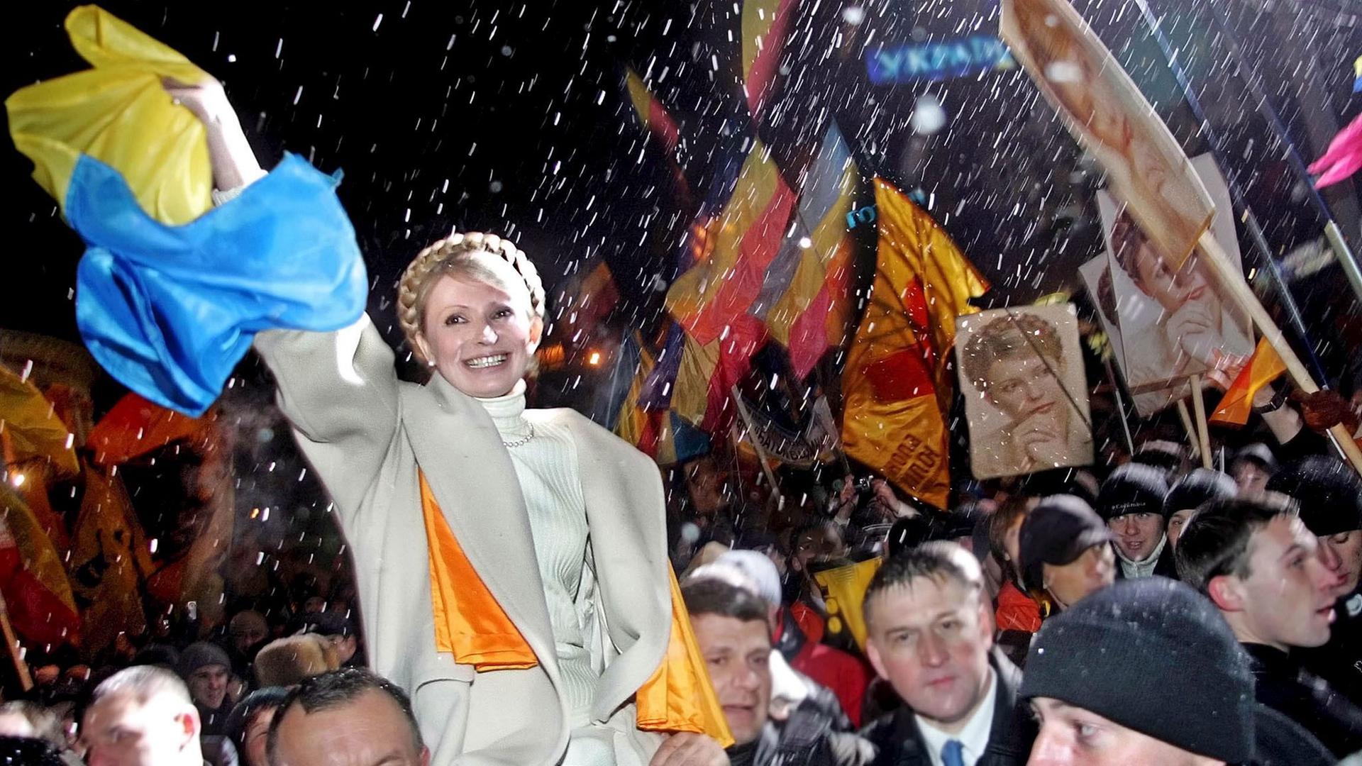 Die ehemalige Premierministerin der Ukraine, Julija Tymoschenko, wird am 22. November 2005 von ihren Anhängern über den Unabhängigkeitsplatz in Kiew getragen. 