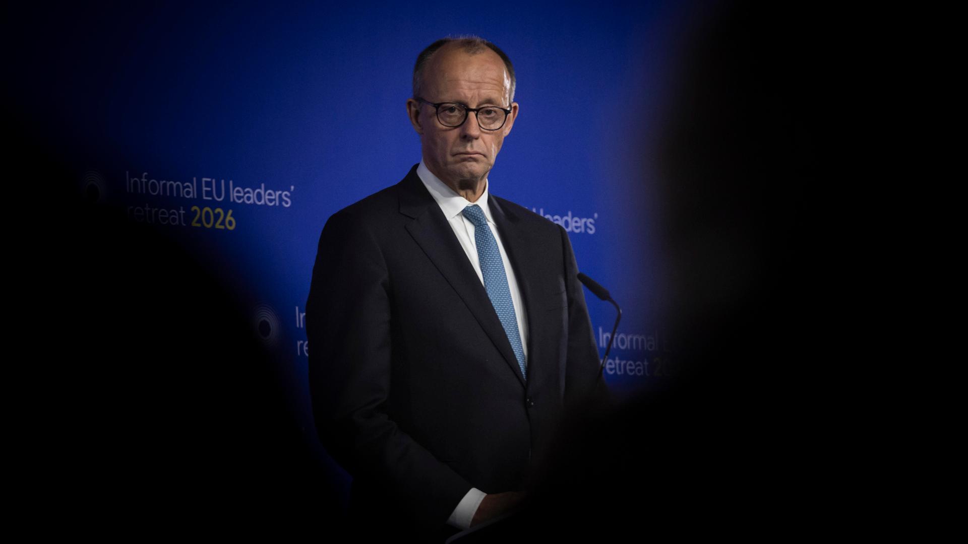 Bundeskanzler Friedrich Merz. Ein älterer Mann im Anzug steht auf einem Podium.