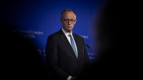 Bundeskanzler Friedrich Merz steht auf einem Podium.