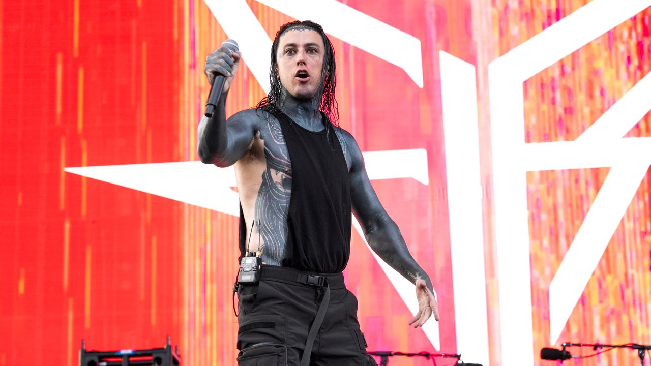 Ronnie Radke schaut bei einem Auftritt mit Mikrofon in der Hand nach vorne.