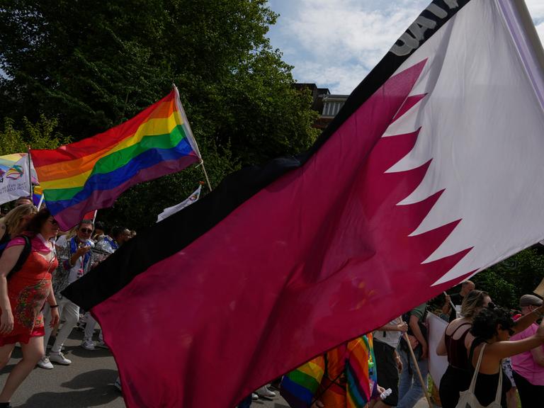 Teilnehmer beim Pride Day in Amsterdam schwenken die Regenbogen-Fahnen und die Flagge von Katar. (AP Photo/Peter Dejong)