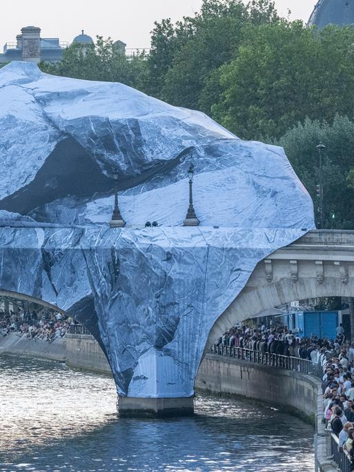 Zu sehen ist die Brücke Pont Neuf in Paris. Mehrere Planen bedecken die oberen Teil der Brücke.