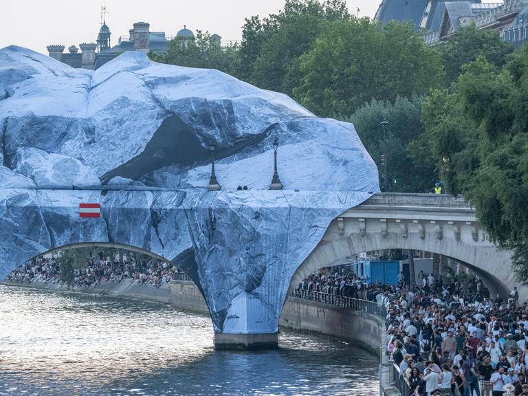 Zu sehen ist die Brücke Pont Neuf in Paris. Mehrere Planen bedecken die oberen Teil der Brücke.