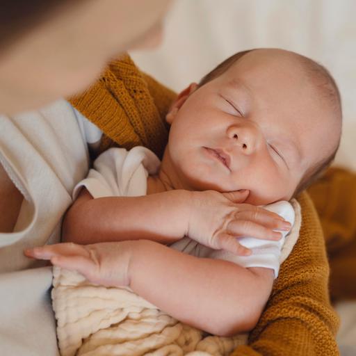 Schlafendes Baby im Arm seiner Mutter