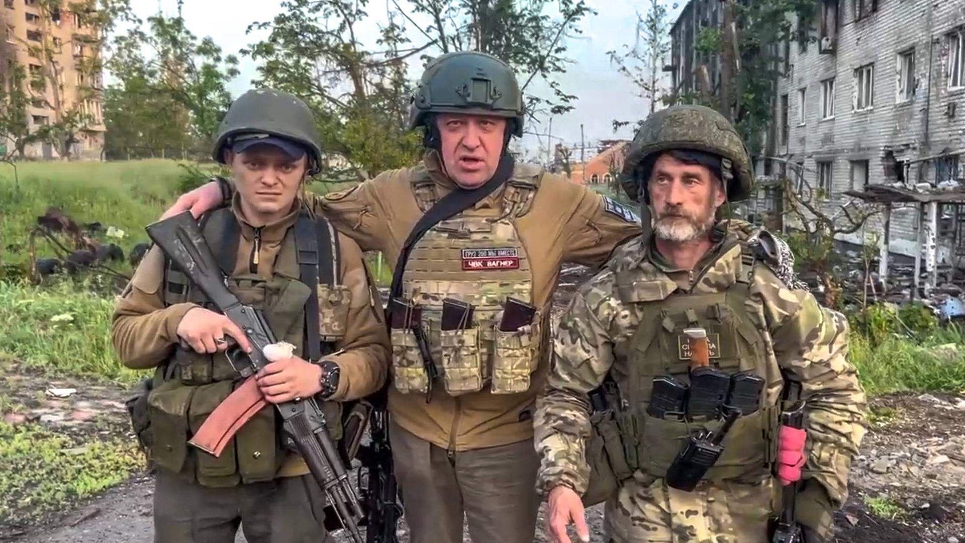 Der Chef der der Wagner Söldnertruppe Jewgeni Prigoschin steht mit zwei seiner Soldaten vor einem zerstörten Strassenzug inder ukrainischen Stadt Bachmut.