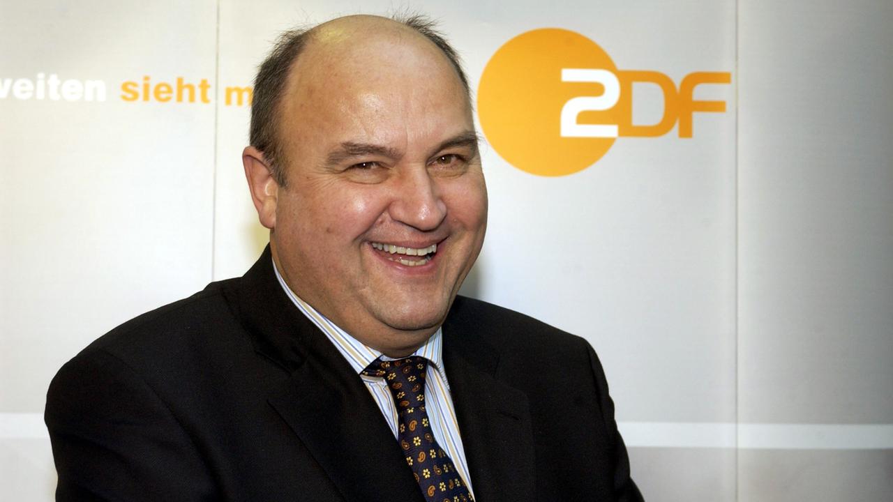 Ekkehardt Gahntz steht vor dem ZDF-Logo und lächelt.