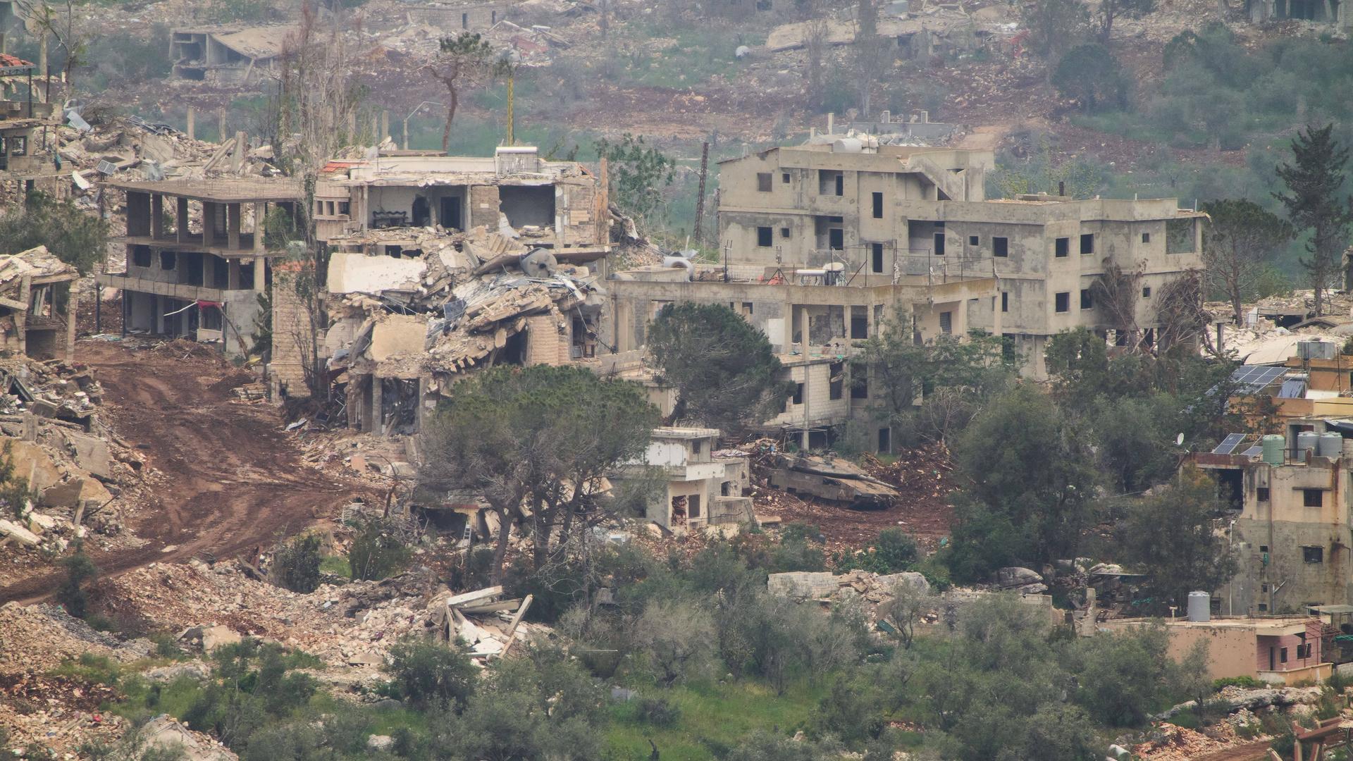 Israelische Soldaten fahren einen Panzer in einem zerstörten Dorf im Südlibanon.