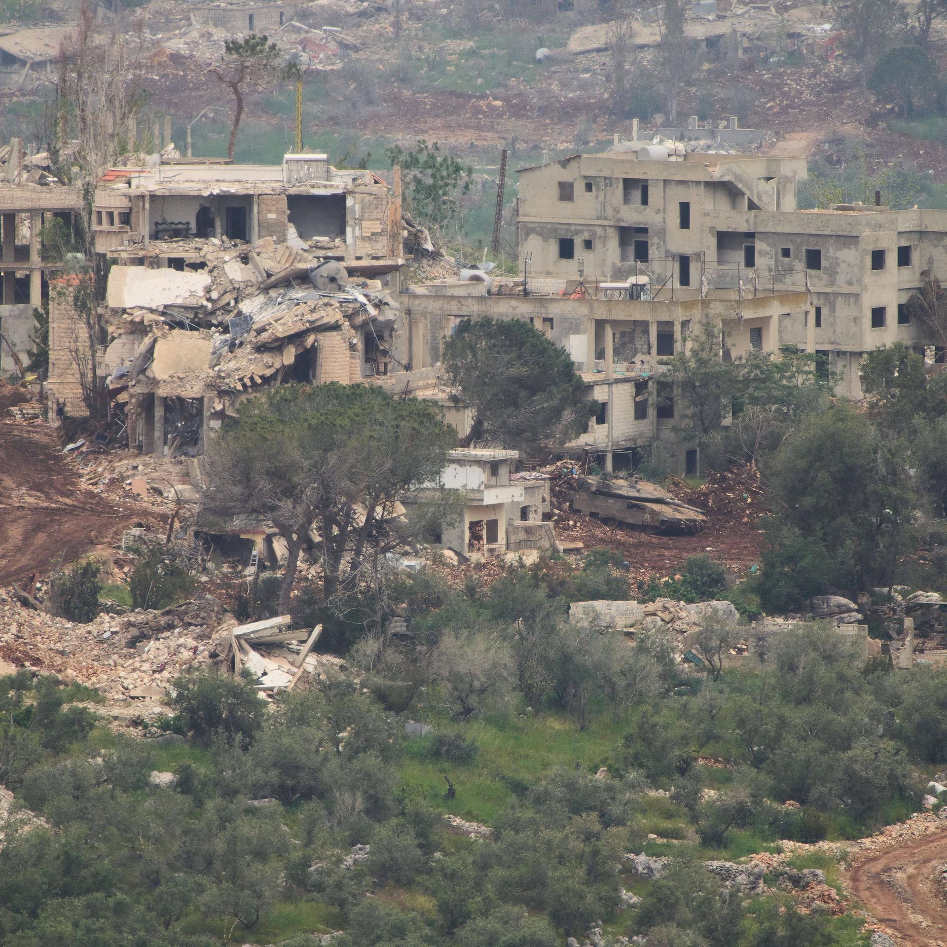 Israelische Soldaten fahren einen Panzer in einem zerstörten Dorf im Südlibanon.