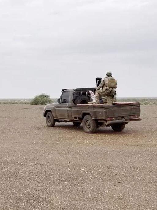 Russische Sölder der Gruppe Wagner auf einem Militärfahrzeug an einem nicht näher bezeichneten Ort in einem afrikanischen Wüstengebiet im August 2023.