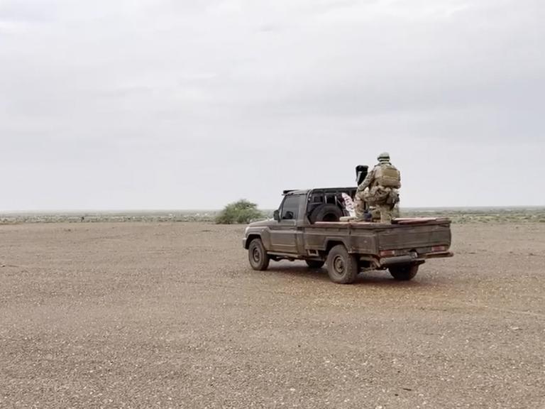 Russische Sölder der Gruppe Wagner auf einem Militärfahrzeug an einem nicht näher bezeichneten Ort in einem afrikanischen Wüstengebiet im August 2023.