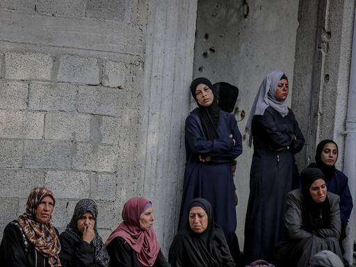 Eine Gruppe palästinensischer Frauen mit Kopftuch im Gazastreifen, wartet auf humanitäre Hilfe. 