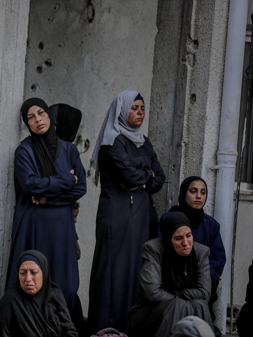 Eine Gruppe palästinensischer Frauen mit Kopftuch im Gazastreifen, wartet auf humanitäre Hilfe. 