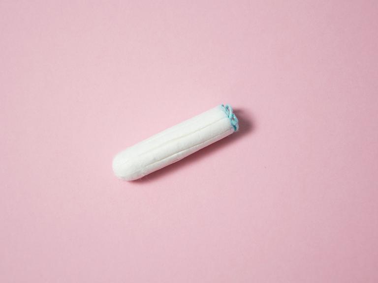 Ein weißer Tampon auf lachsfarbenem Hintergrund.