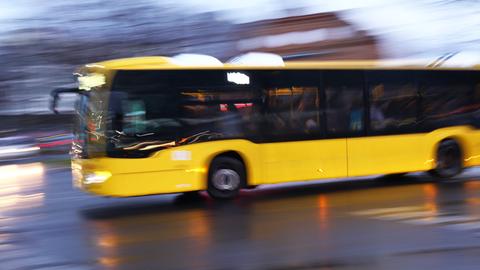 Ein gelber Bus fährt abends, die Darstellung ist verschwommen 