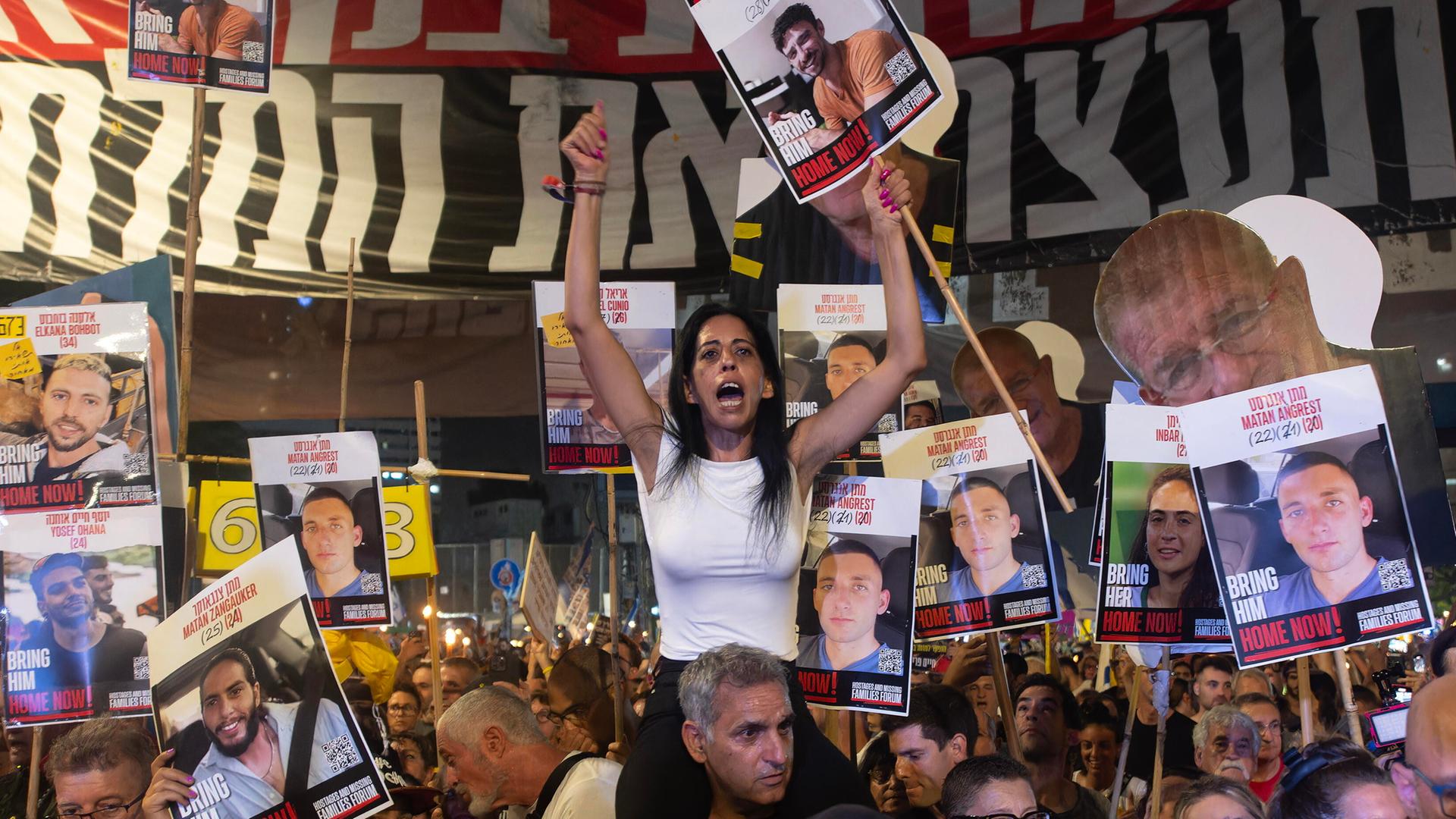 Auf einer Demonstration in Tel Aviv People fordern Protestierende die Freilassung der Hamas-Geiseln und ein Ende des Krieges in Gaza. In der Mitte sitzt eine Frau auf den Schultern eines Mannes, sie trägt ein Plakat mit dem Foto einer Geisel. Auf einer Demonstration in Tel Aviv People fordern Protestierende die Freilassung der Hamas-Geiseln und ein Ende des Krieges in Gaza. In der Mitte sitzt eine Frau auf den Schultern eines Mannes, sie trägt ein Plakat mit dem Foto einer Geisel.
