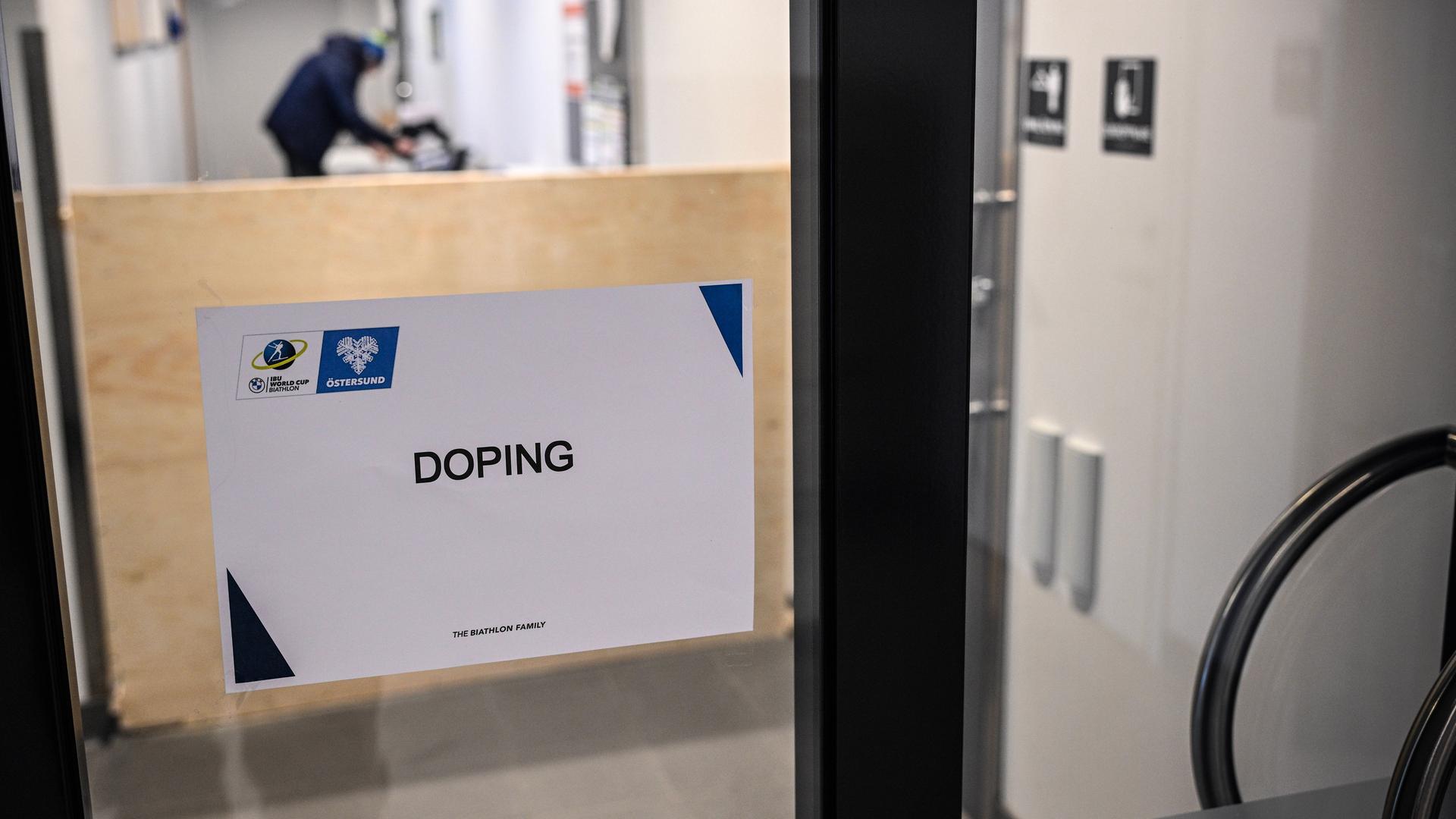 Ein Schild mit der Aufschrift "Doping" an einer Glastür.