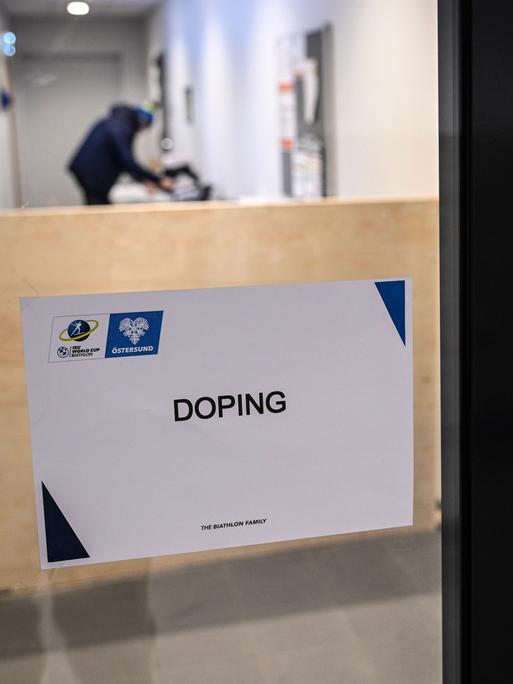 Ein Schild mit der Aufschrift "Doping" an einer Glastür.