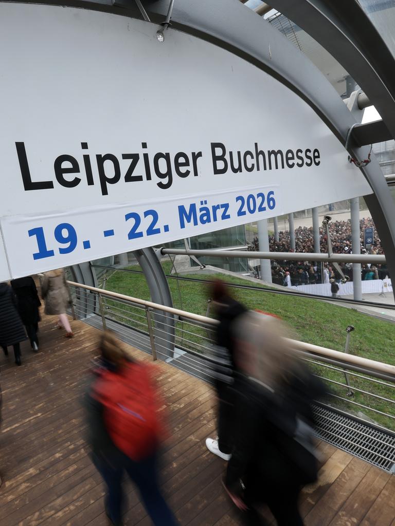 Besucher strömen auf die Leipziger Buchmesse 2025. Ein Schild kündigt die nächste Ausgabe an.