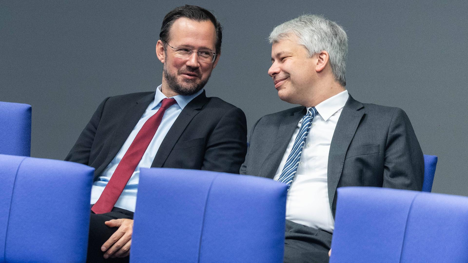 Die Politiker Dirk Wiese und Steffen Bilger sitzen auf blauen Stühlen im Bundestag nebeneinander. Die Politiker Dirk Wiese und Steffen Bilger sitzen auf blauen Stühlen im Bundestag nebeneinander.