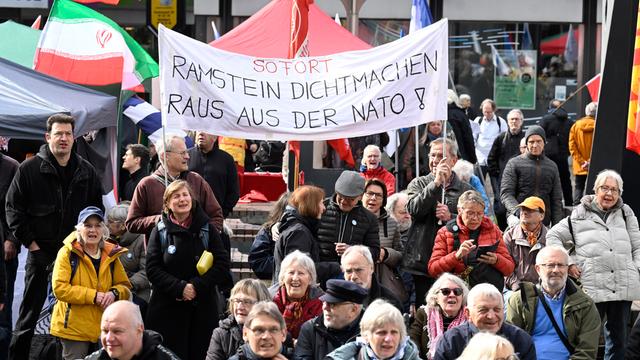 Teilnehmer stehen am Start des traditionellen Ostermarschs hinter einem Transparent mit der Aufschrift "Sofort Ramstein dichtmachen, raus aus der Nato".