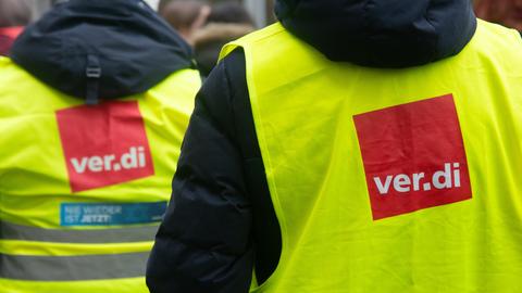 Streik des öffentlichen Dienst: Menschen mit Warnwesten stehen beieinander. Auf den gelben Westen ist das Logo der Gewerkschaft Verdi: ein rotes Viereck mit weißer Schrift "Verdi".