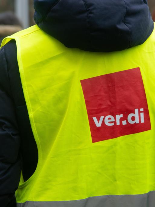 Streik des öffentlichen Dienst: Menschen mit Warnwesten stehen beieinander. Auf den gelben Westen ist das Logo der Gewerkschaft Verdi: ein rotes Viereck mit weißer Schrift "Verdi".