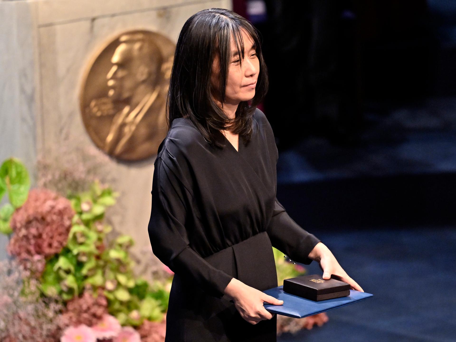 Han Kang, Nobelpreistägerin in Literatur, hält ihre Auszeichnung bei der Verleihung in Stockholm im Jahr 2024. Han Kang, Nobelpreistägerin in Literatur, hält ihre Auszeichnung bei der Verleihung in Stockholm im Jahr 2024.