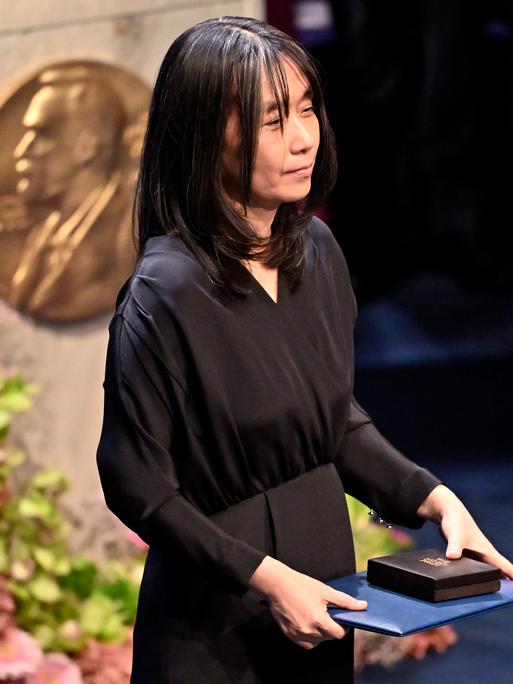Han Kang, Nobelpreistägerin in Literatur, hält ihre Auszeichnung bei der Verleihung in Stockholm im Jahr 2024. Han Kang, Nobelpreistägerin in Literatur, hält ihre Auszeichnung bei der Verleihung in Stockholm im Jahr 2024.