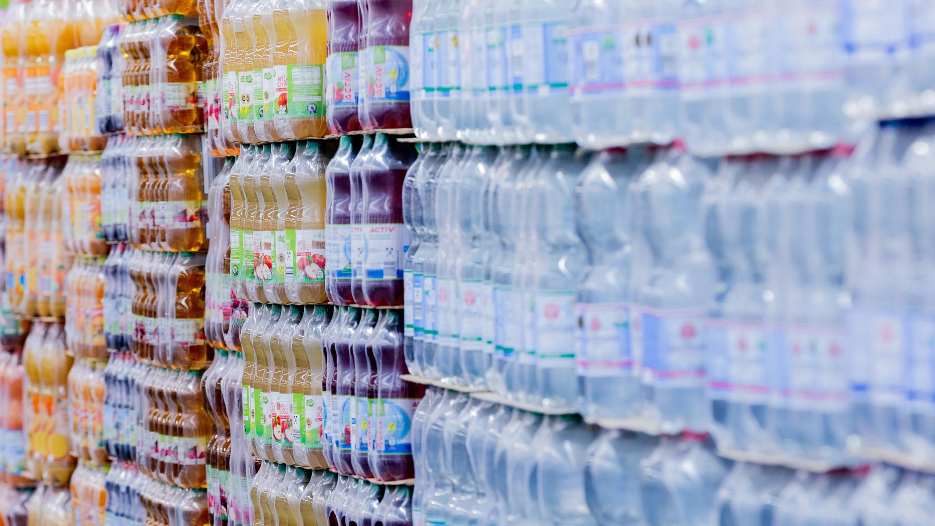 Einweg-Plastikflaschen stehen in einem Supermarkt auf Paletten.