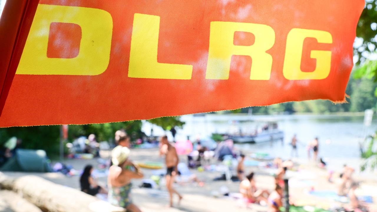 Ein Fahne der Deutschen Lebens-Rettungs-Gesellschaft weht am Tegeler See in Berlin an einer Badestelle. 