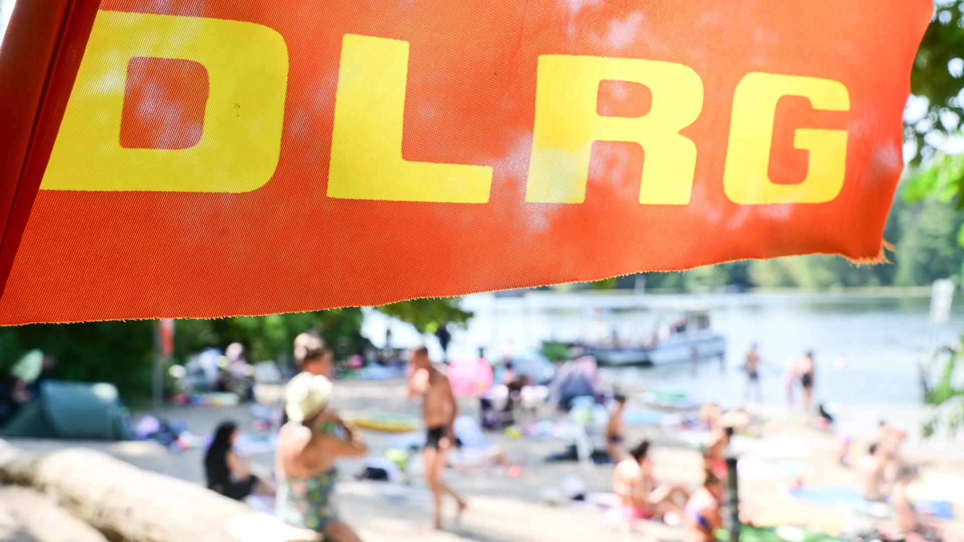 Ein Fahne der Deutschen Lebens-Rettungs-Gesellschaft weht am Tegeler See in Berlin an einer Badestelle. 